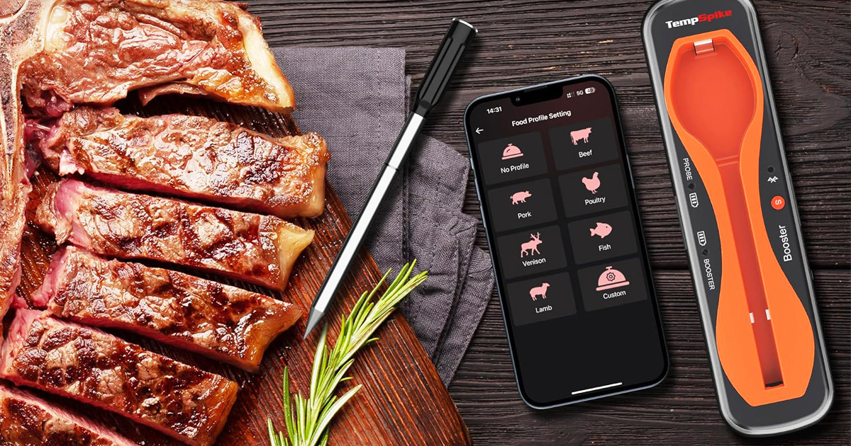Wireless meat thermometer beside sliced grilled steak with a smartphone app displaying cooking profiles and a Bluetooth temperature probe on a wooden table.