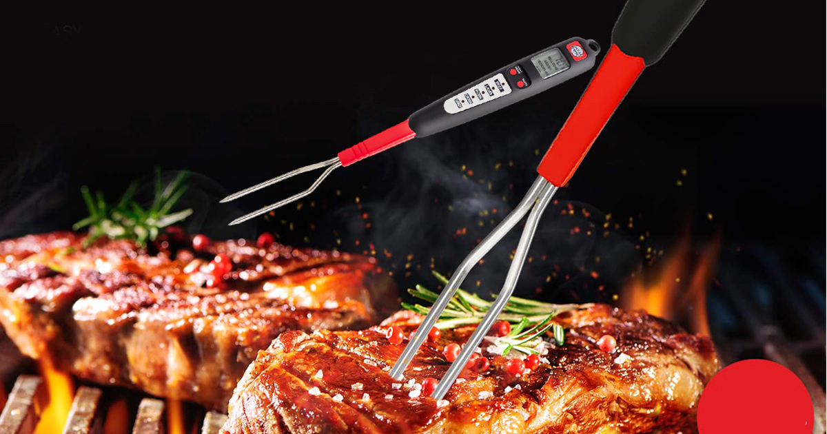 Digital meat thermometer fork checking doneness of grilled steaks over an open flame, with stainless steel prongs and a heat-resistant handle for safe barbecue cooking