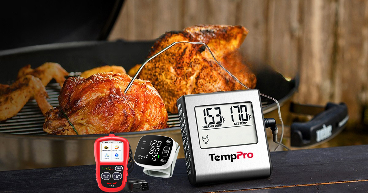 Digital meat thermometer monitoring grilled chicken on a barbecue, with an OBD2 automotive engine fault code reader and a digital blood pressure monitor displayed in the foreground