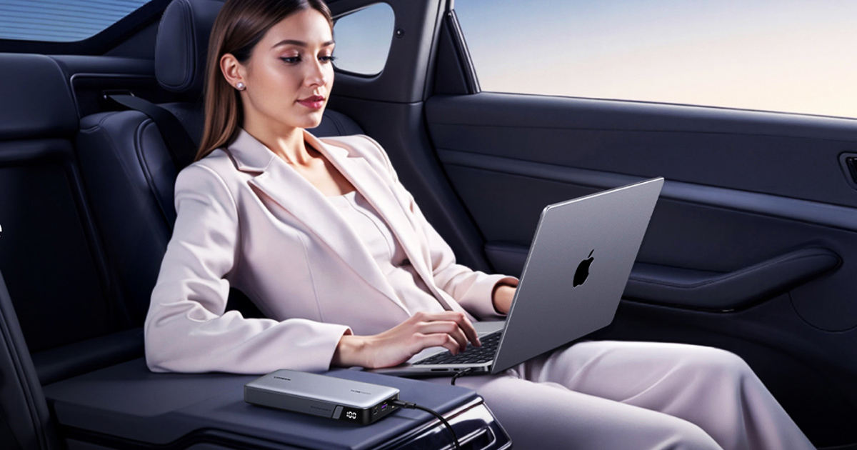 Woman traveler using a laptop in her car while it charges from a portable power bank.